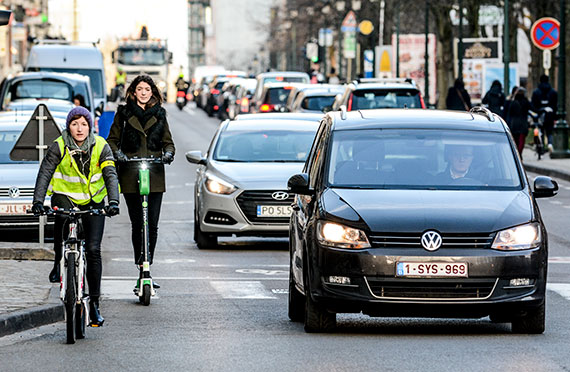 Verkeer in Brussel, auto's, een fiets en een step.