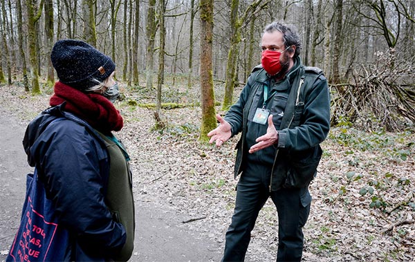 Een boswachter sensibiliseert wandelaars voor de bescherming van het bos.