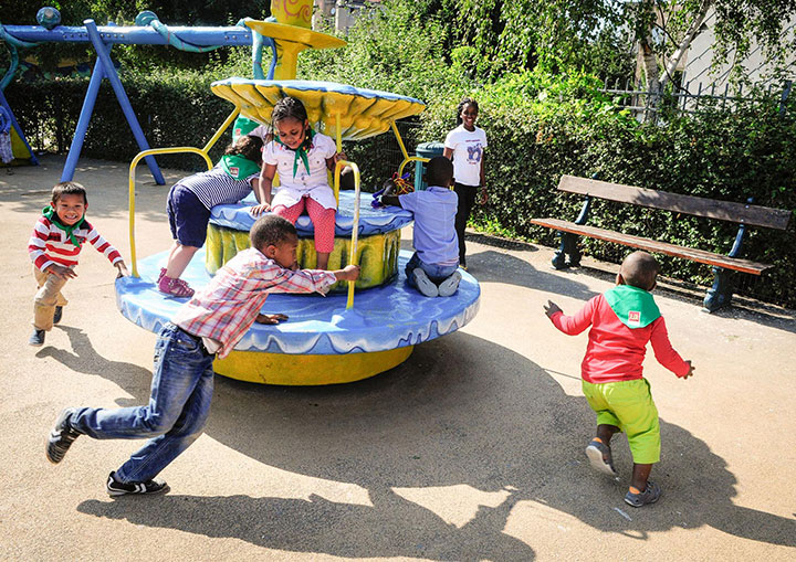 Kinderen spelen in een buitenspeeltuin.
